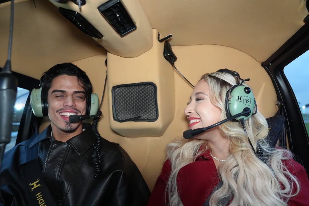 Mulher sorrindo com fone de aviação dentro de um helicóptero
